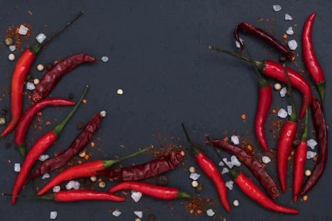 Hot chilli sauce paste with fresh and cracked pepper on black slate backgroun Stock Photos