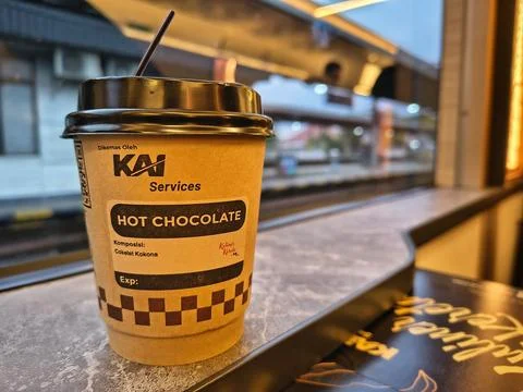 Hot chocolate cup on a train table with station view from window Stock Photos