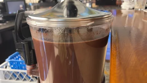 Hot chocolate dispenser Serving steamy hot coffee out of a percolator. Stock Footage 301999631