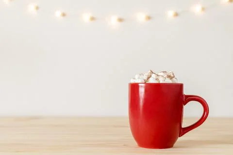 Hot chocolate in red mug with small marshmallows on wooden table with holiday Stock Photos