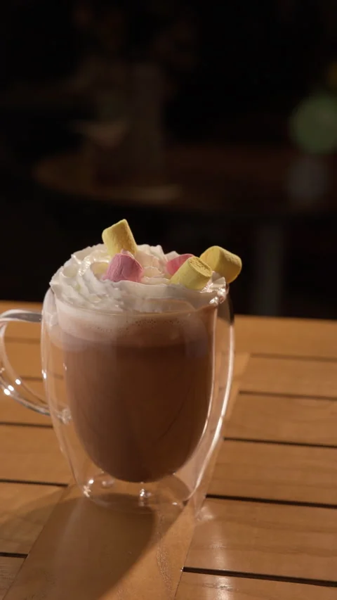 Hot chocolate sprinkled with marshmallows. Hot cacao in a doubled-walled Stock Footage 326437848