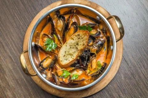 Hot clam chowder and vegetables, cooked in a pot. Stock Photos