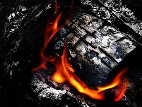 Hot coals and flames in buring campfire Stock Photos
