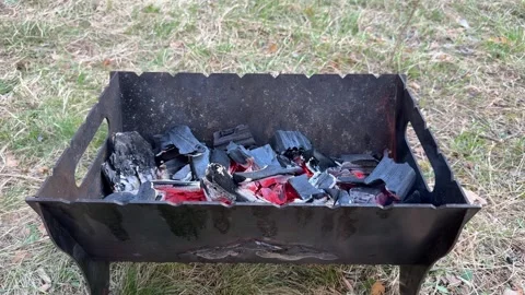 Hot coals and small flame in portable barbecue grill Stock Footage 334068292