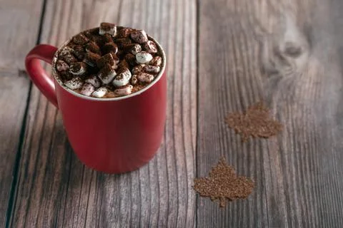 Hot cocoa beverage with marshmallows in red mug on wooden table featuring cocoa 写真素材