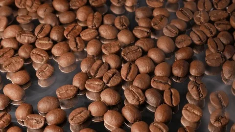 Hot coffee beans close-up with mirror reflection, with smoke Stock Footage 74775138