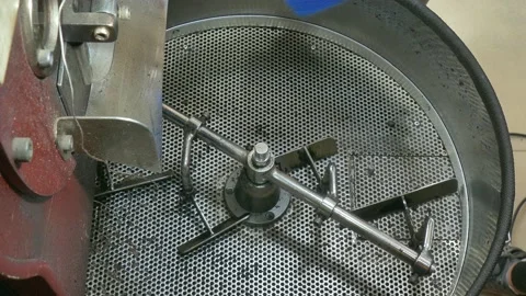 Hot coffee beans flowing into cooling tray of coffee roaster machine. Vidéo 135707452
