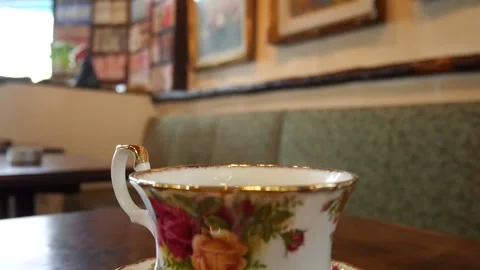 Hot coffee in beautiful flower cup in a coffee shop Stock Footage 164515519