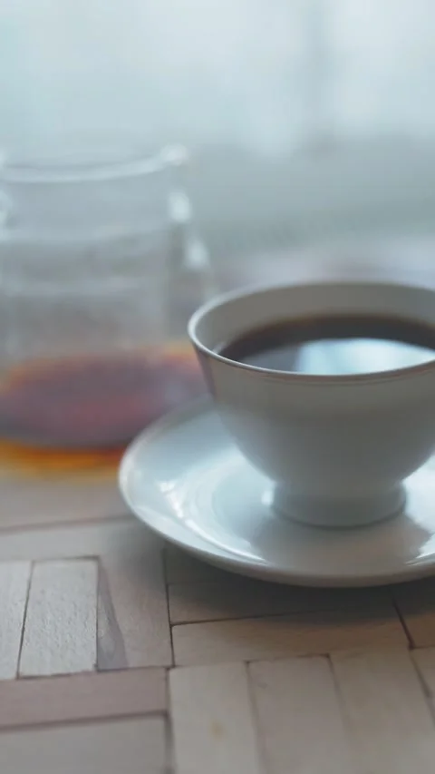 Hot coffee being poured into a white antique ceramic cup Stock Footage 340107599