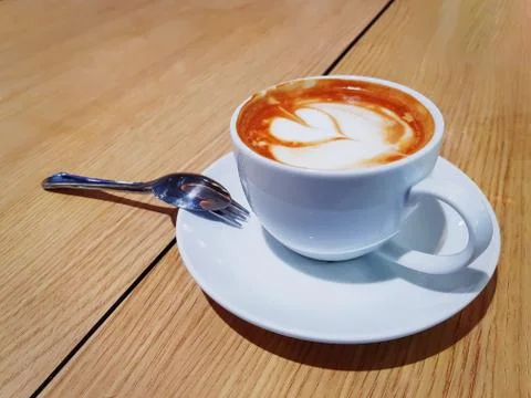 Hot Coffee with Creamy Leaf Pattern Foam in White Cup Foto stock