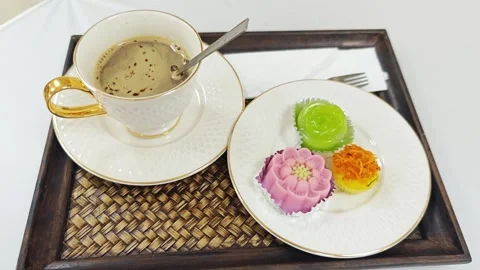 Hot coffee cup with assorted traditional Thai desserts on a wooden tray. 스톡 동영상 344035228