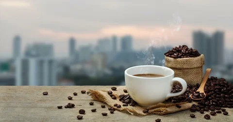 Hot Coffee cup with Coffee beans on the wooden table and the city background Stock-Footage 84464721