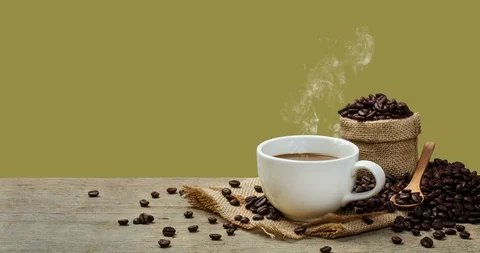 Hot Coffee cup with Coffee beans on the wooden table and the green background Stock Footage 100660469