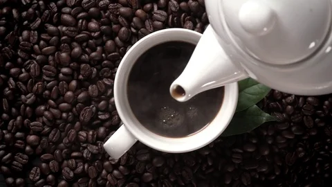 Hot coffee cup with coffee beans on the wooden table Stock Footage 104949991