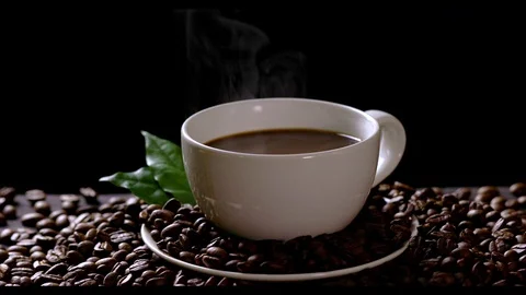 Hot coffee cup with coffee beans on the wooden table Stock Footage 105003856