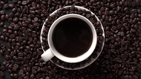 Hot coffee cup with coffee beans on the wooden table Stock Footage 105144493