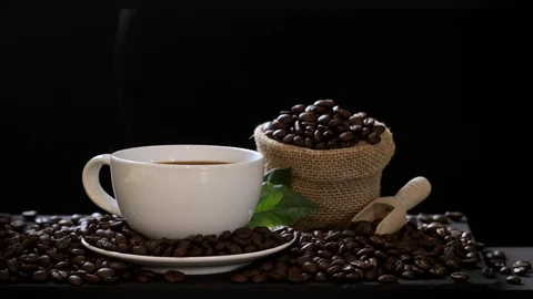 Hot coffee cup with coffee beans on the wooden table Stock Footage 105144773