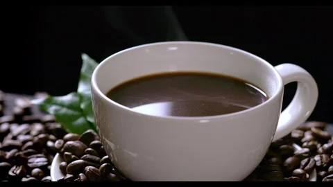 Hot coffee cup with coffee beans on the wooden table Stock Footage 105224110