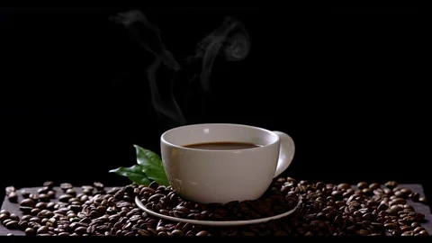 Hot coffee cup with coffee beans on the wooden table Stock Footage 105524638