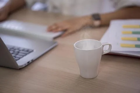 Hot coffee cup on computer table Stock Photos