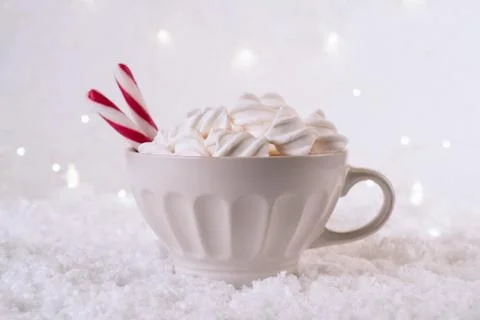 Hot Coffee cup with marshmallows and red candy cane on a frosty winter backgr Stock-Fotos