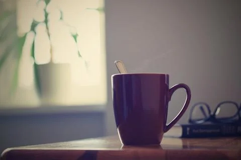 Hot coffee cup on the table, window background, cozy home Stock Photos