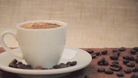 Hot Coffee cup on a wooden table with coffee beans Stock Footage 80995786