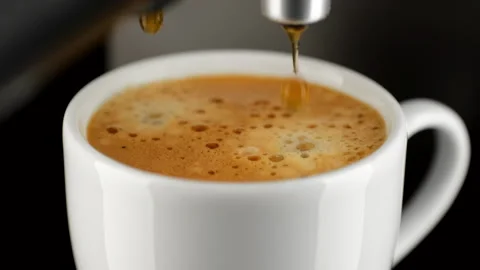 Hot coffee espresso from coffee machine pour in white cup Stock Footage 248135073