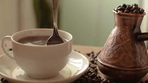 Hot coffee mug on the table. Turk for coffee full of beans. HD Stock-Footage 101691760