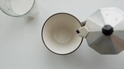 Hot coffee is poured from mokacoffee maker into cup Stock Footage 86821573