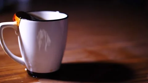 Hot coffee sloshing out of an over filled mug onto a table Video stock 153700032