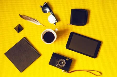 Hot coffee, a tablet and a camera, a purse and glasses. notepad for writing.  Fotos Stock