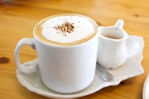 Hot coffee in a white cup on table Stock Photos