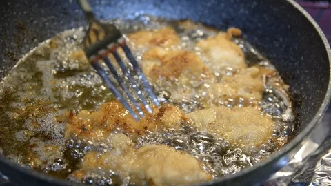 Hot cooking oil in a frying pan with chicken nuggets Video stock 100503953