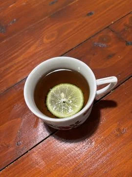Hot Cup of Tea with Lemon Slice on Rustic Wooden Table Foto stock