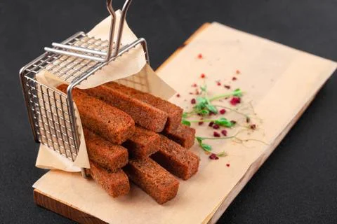 Hot deep-fried dark bread sticks, scattered from grid Stock Photos