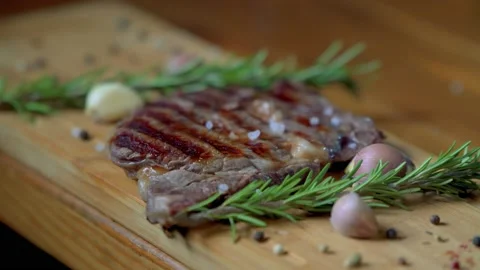 Hot delicious beefsteak with salt, garlic and rosemary Stock Footage 170282995