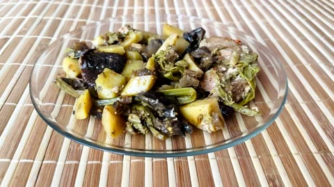 The hot dish includes baked potatoes, eggplant, mushrooms, Far Eastern bracken Stock Footage 302097564