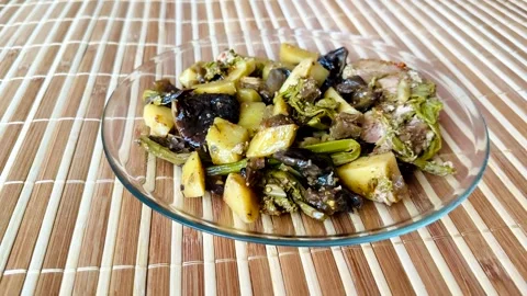 The hot dish includes baked potatoes, eggplant, mushrooms, Far Eastern bracken Stockbeeldmateriaal 302099447