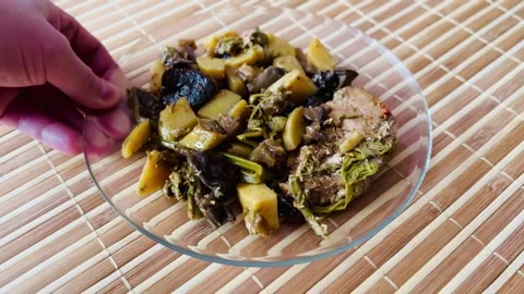 The hot dish includes baked potatoes, eggplant, mushrooms, Far Eastern bracken Stock Footage 302100588
