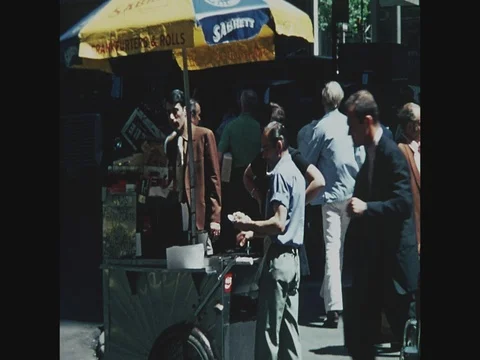 Hot Dog cart with man selling hot dog on street in New York, 1971, cabs and Stock Footage