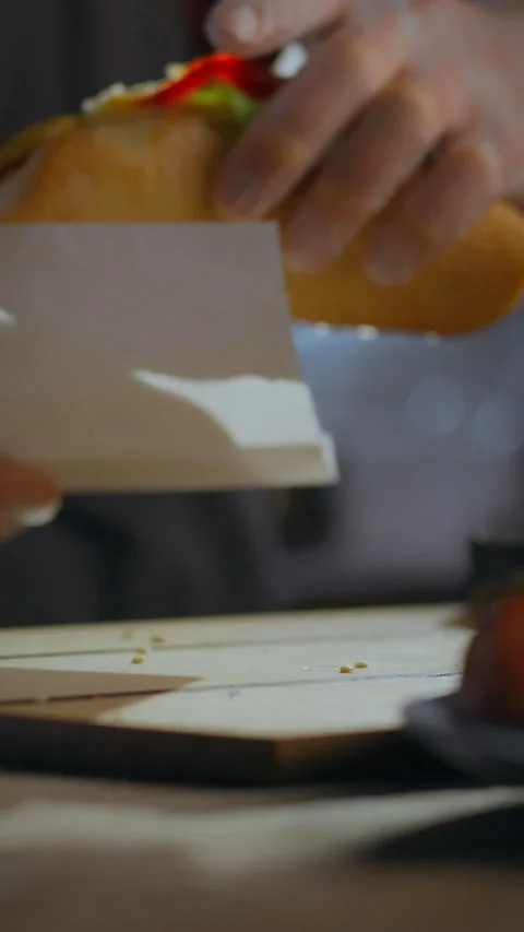 Hot dog chef efficiently prepares an order at a mobile counter in a lively s Vidéo 331594086