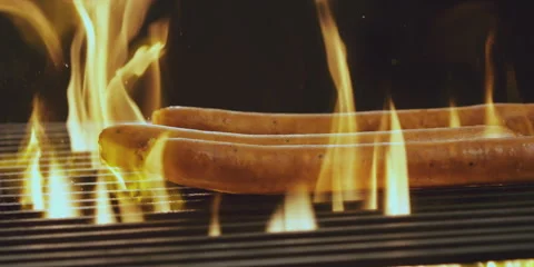Hot dogs falling on grill Stock Footage 247386530