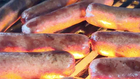 Hot dogs on grill, flames Stockbeeldmateriaal 337577693
