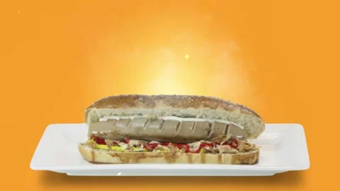 Hot dogs with a sausage on white plate on orange background Stock Footage 135279953