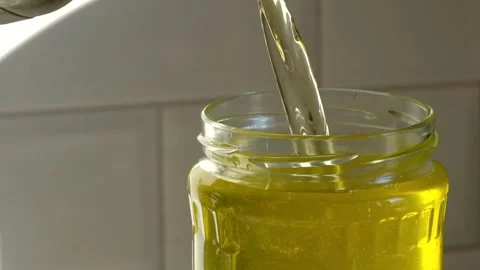 Hot drawn ghee butter pouring in glass jar Stock Footage 166830260