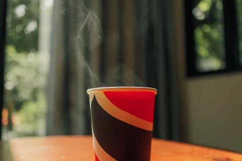 Hot drink in a paper cup on the table in morning light. Stock-Fotos
