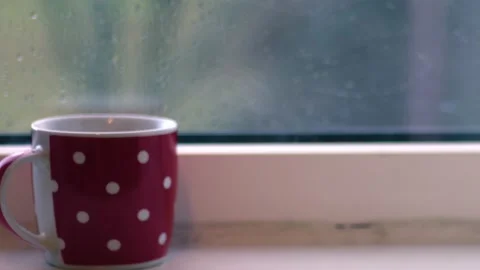 Hot drink in the window on rainy day Stock Footage 228990936