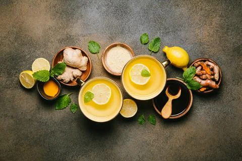 Hot drinks with ginger, lemon and mint in a cups. Lemon, ginger, honey, and t Stock Photos