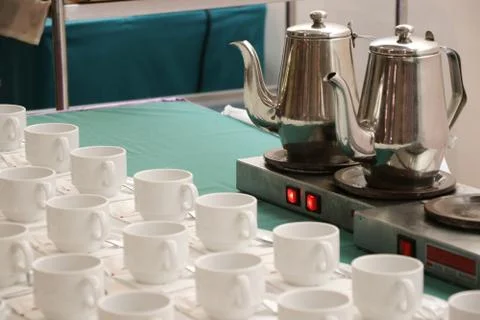 Hot Electric kettle with cups puting on green fabric at Hotel table Stock Photos